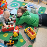 Ohjaaja leikkii lapsen kanssa liikennematolla